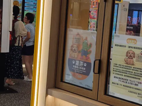 圍方大家樂門外的食環署狗隻進入食肆許可標誌及延遲開放告示